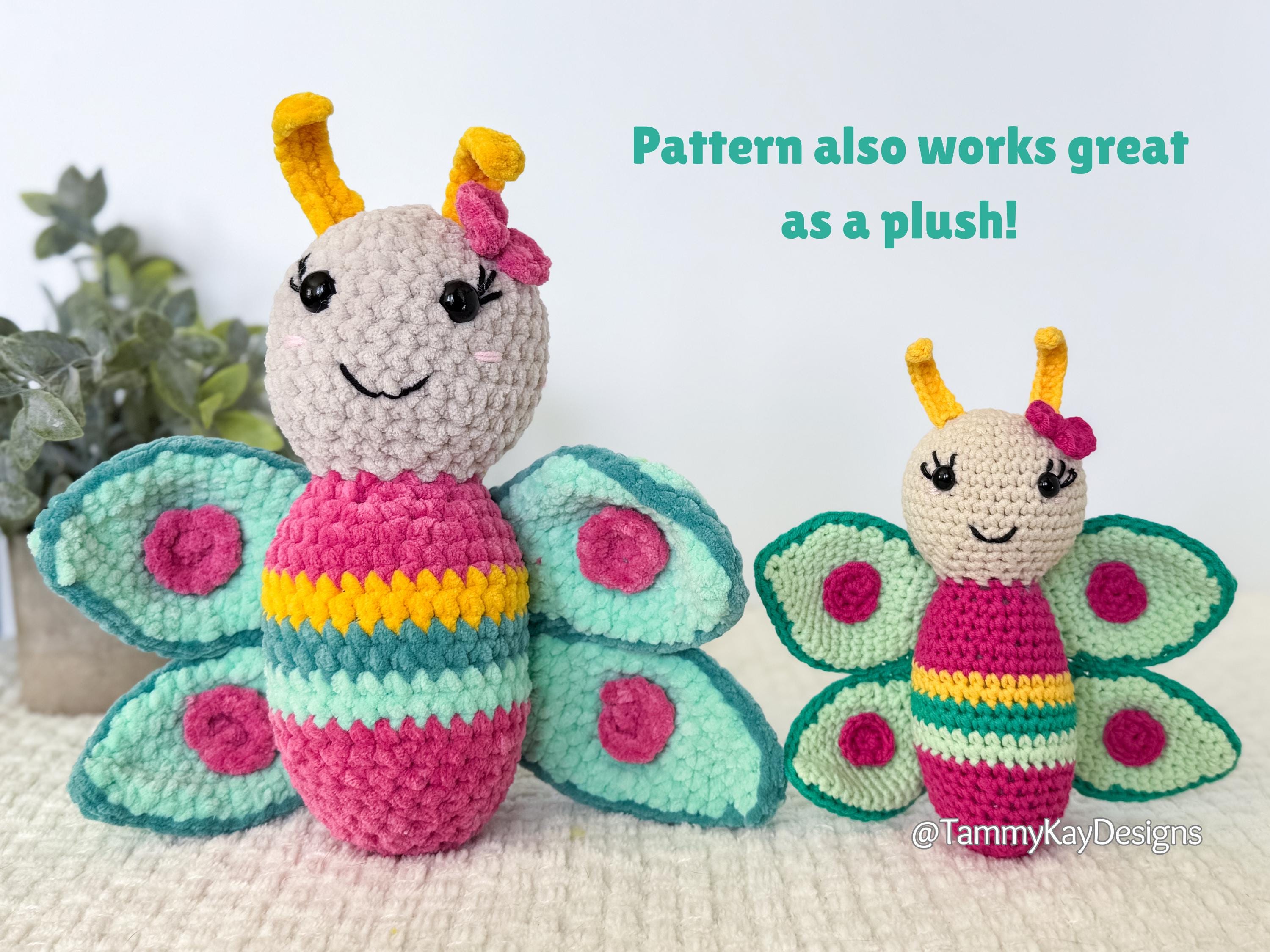 Two crocheted butterfly dolls with pink bodies, green wings, and yellow antennae on a white background.