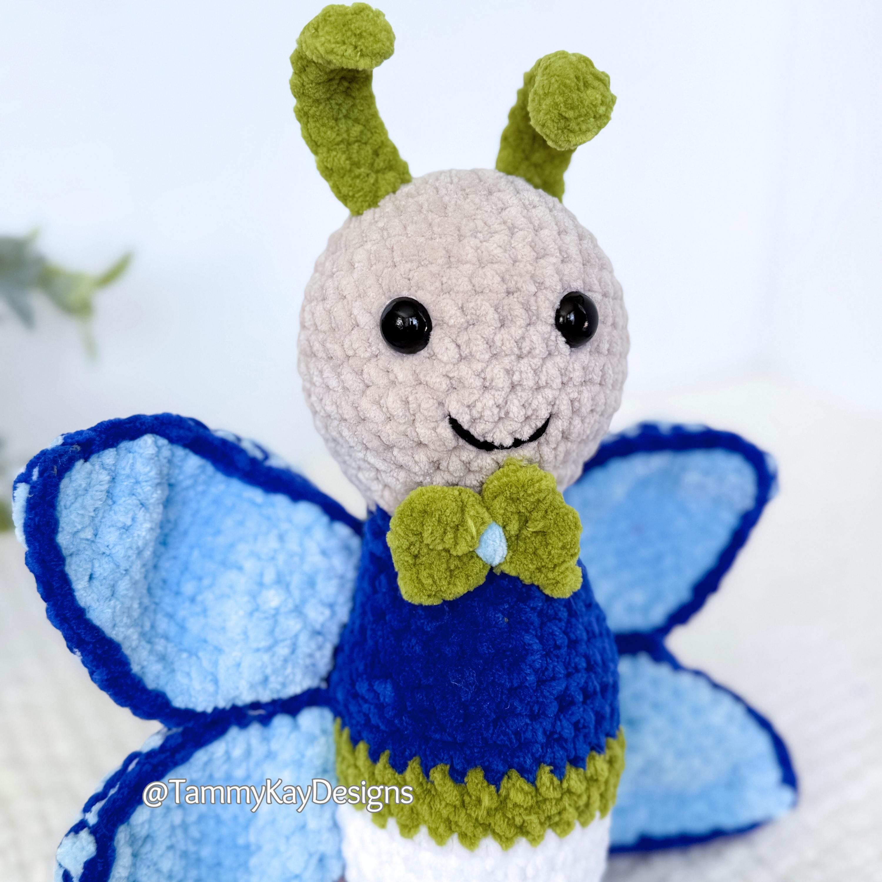 Crocheted butterfly toy with green antennae and bow tie on a light background
